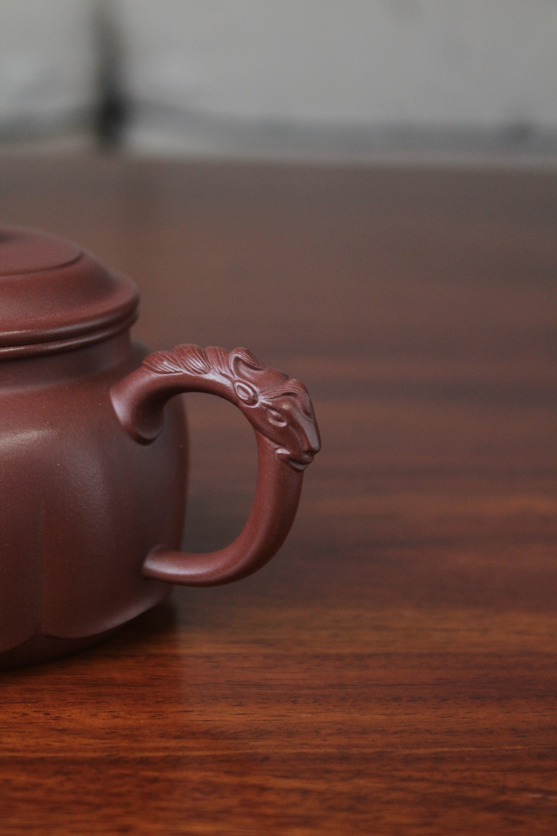 The handle of the yixing clay teapot on the table