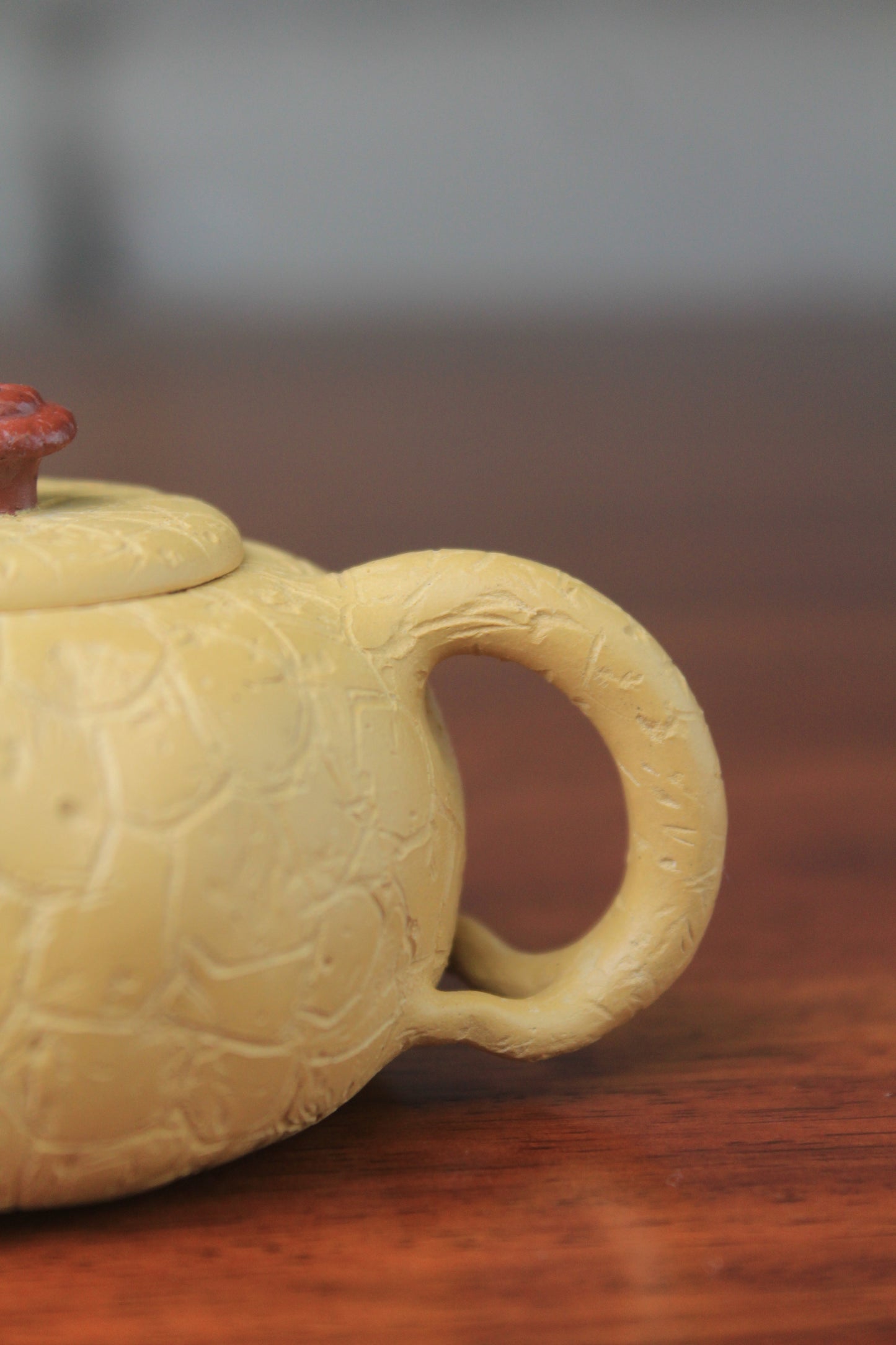 The handle of the yixing clay teapot on the table