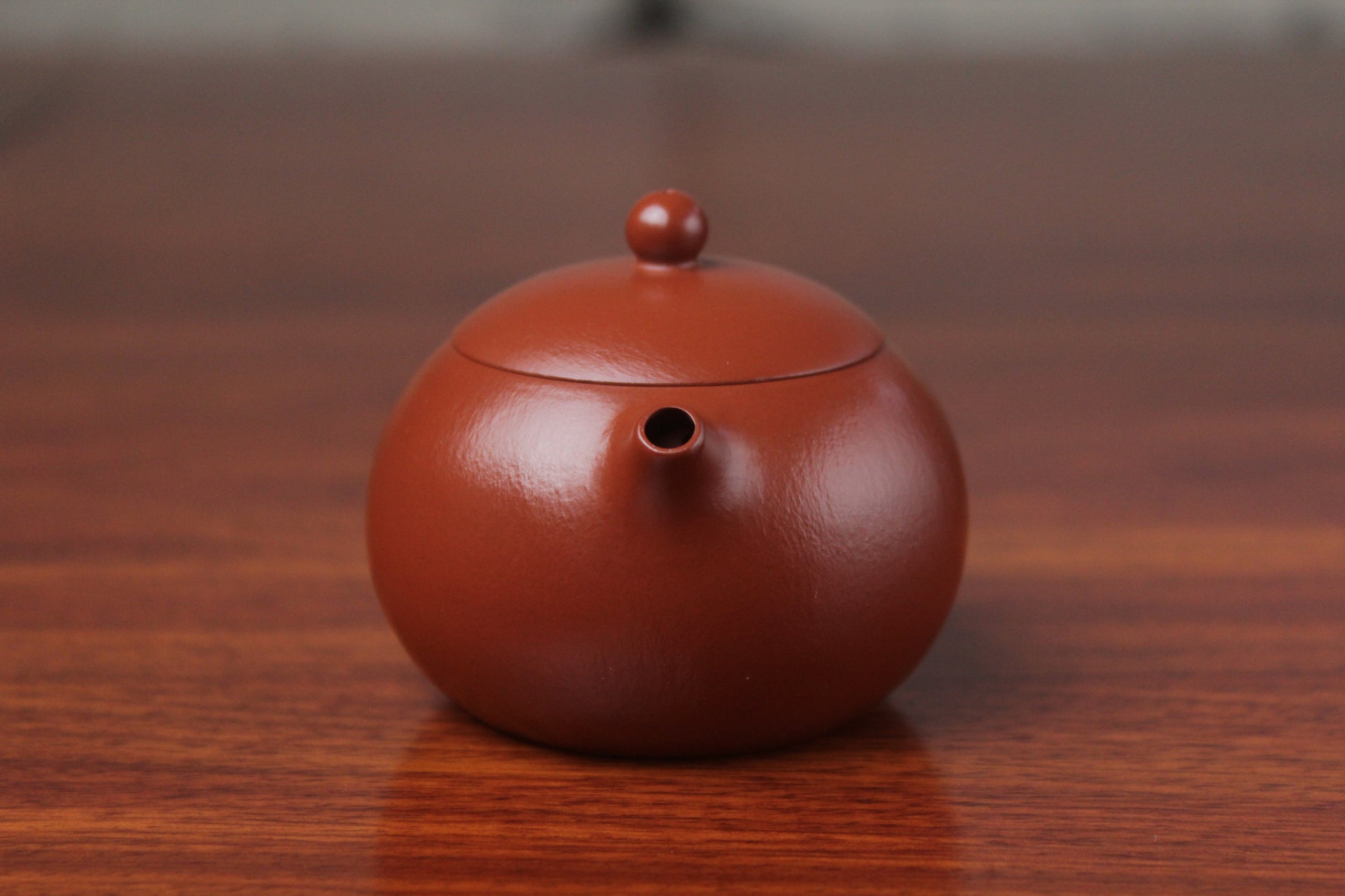 spout of the yixing clay teapot xishi on the table front view