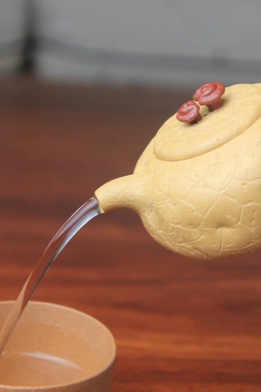 The pour of the yixing clay teapot on the table