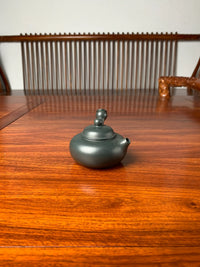 A side view of the lid and body of the teapot