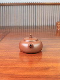 a yixing zisha teapot on the table  handmade by artist