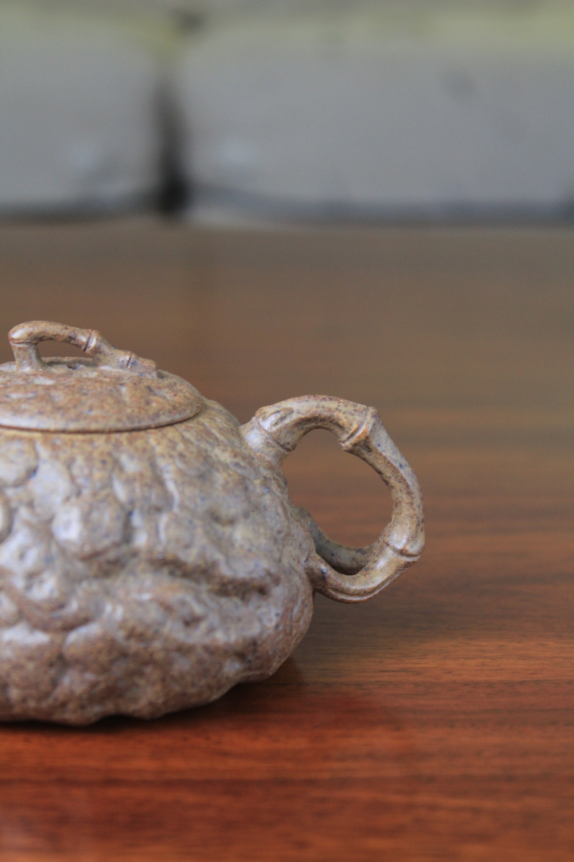handle of yixing teapot gong chun fully handmade with purple clay on the table