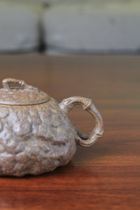 handle of yixing teapot gong chun fully handmade with purple clay on the table