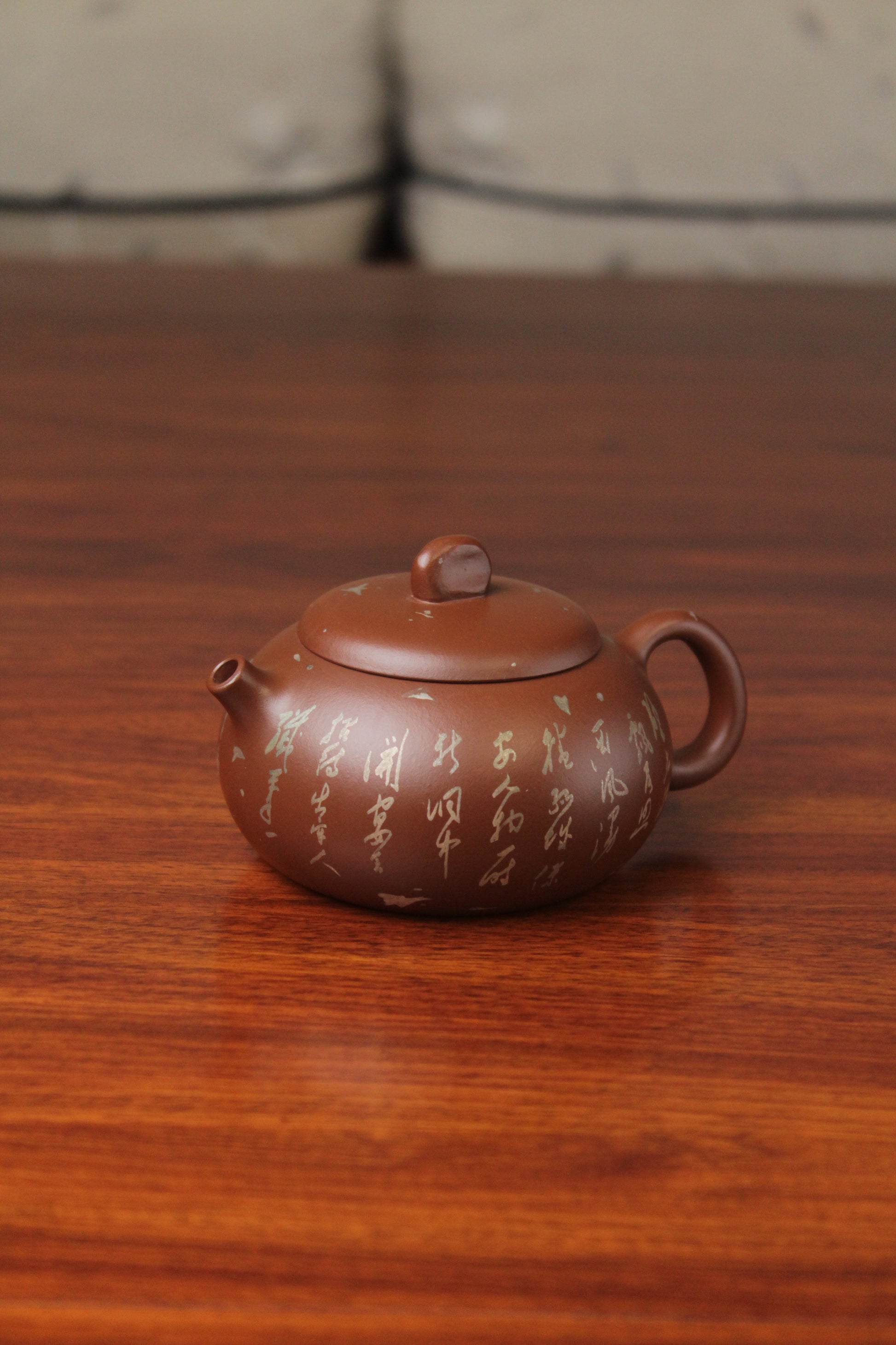 left of the yixing teapot on the table
