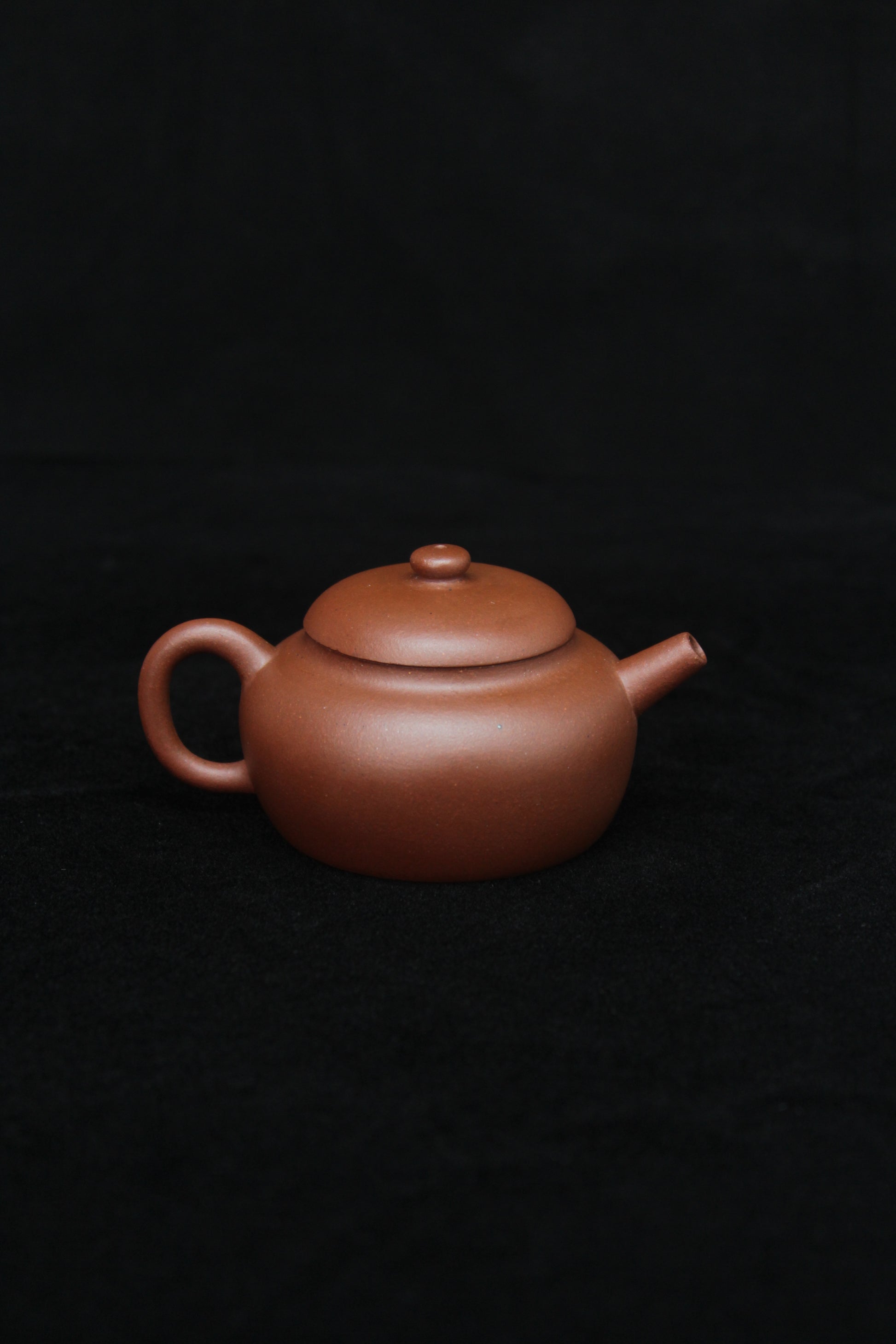 Back of a vintage small Yixing teapot made of dicaoqing purple clay