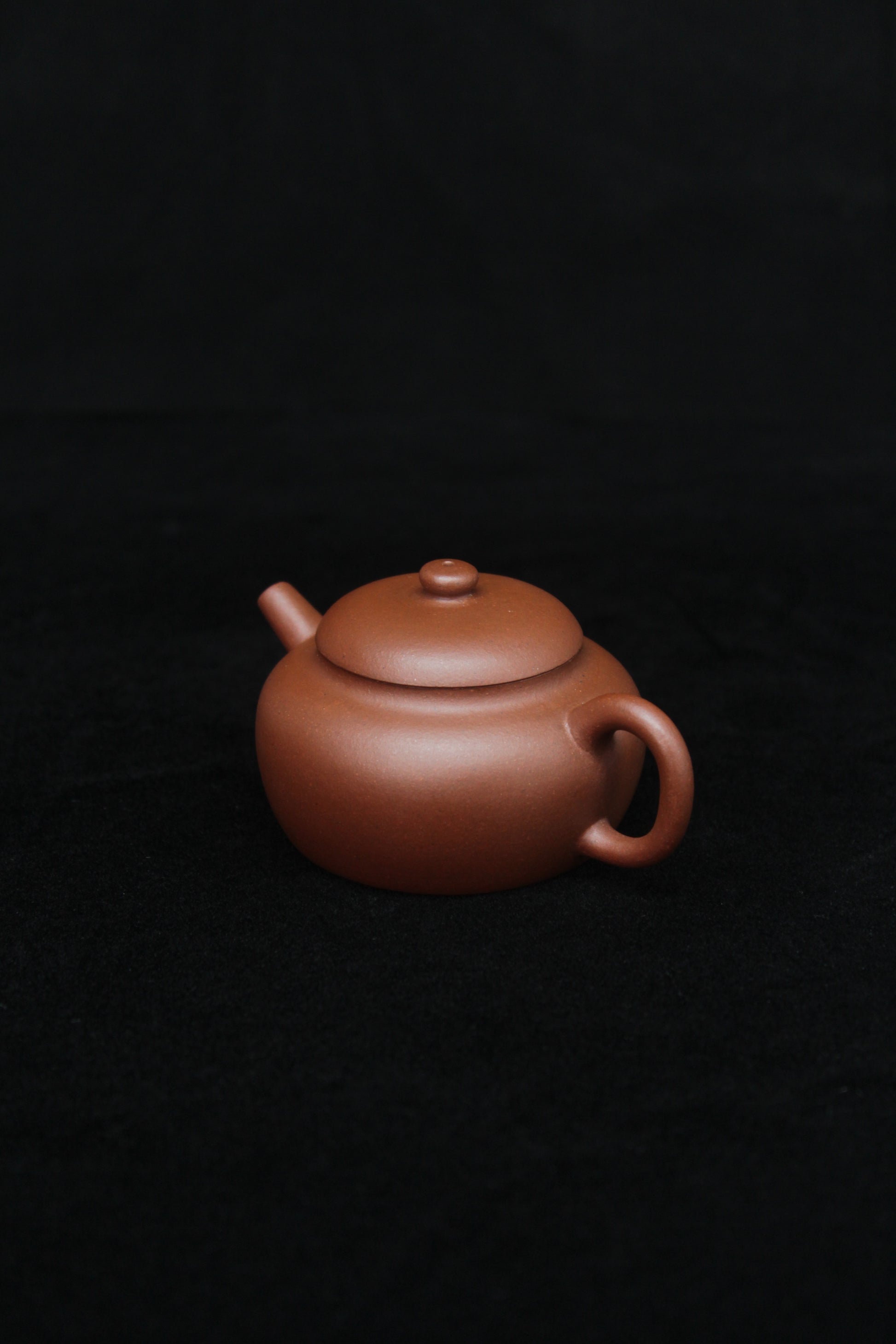 Right of a vintage small Yixing teapot made of dicaoqing purple clay