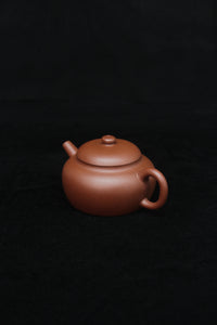 Right of a vintage small Yixing teapot made of dicaoqing purple clay