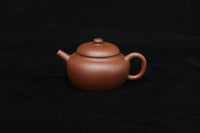 Front of a vintage small Yixing teapot made of dicaoqing purple clay