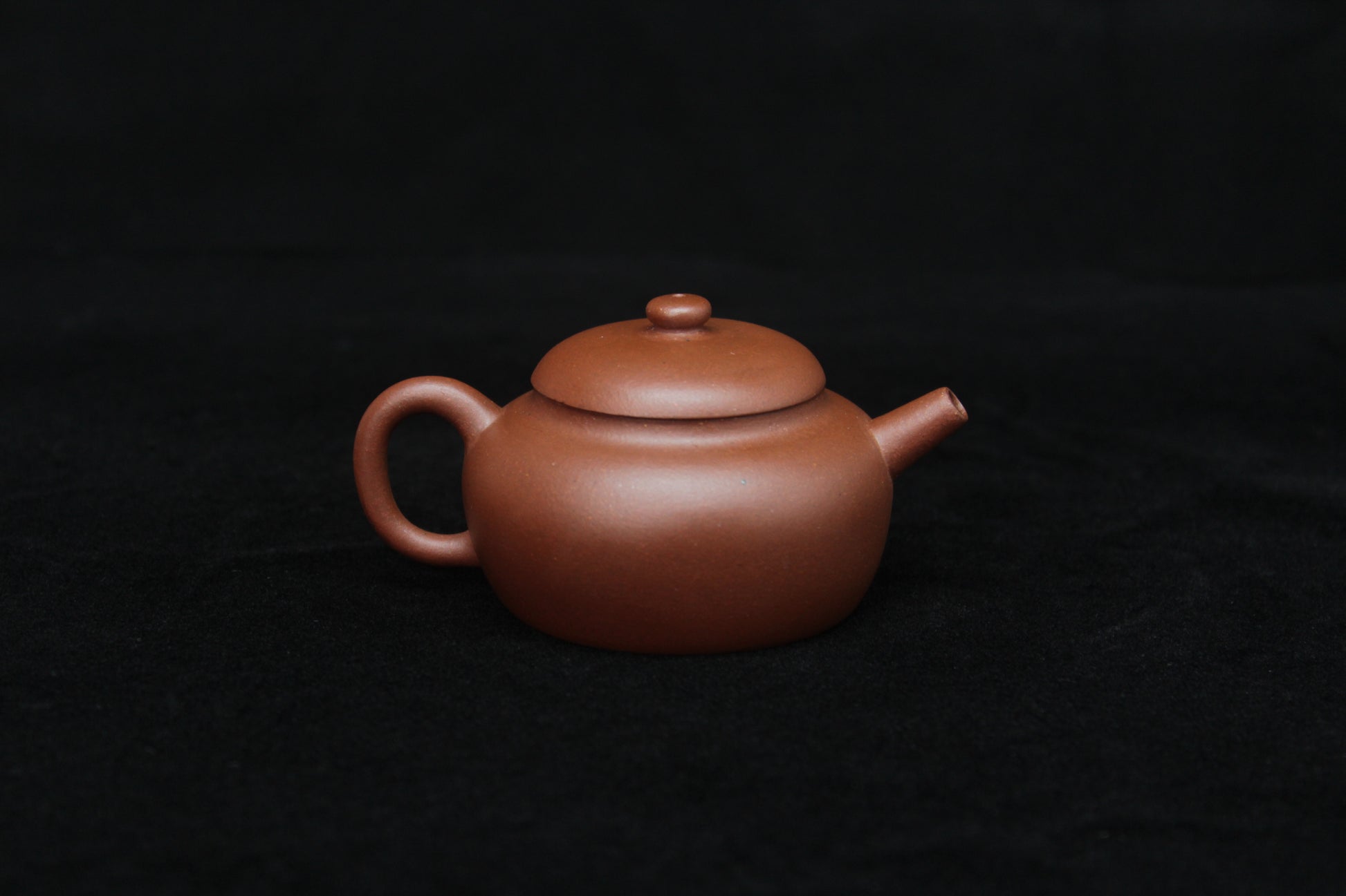 Back detail of a vintage small Yixing teapot made of dicaoqing purple clay