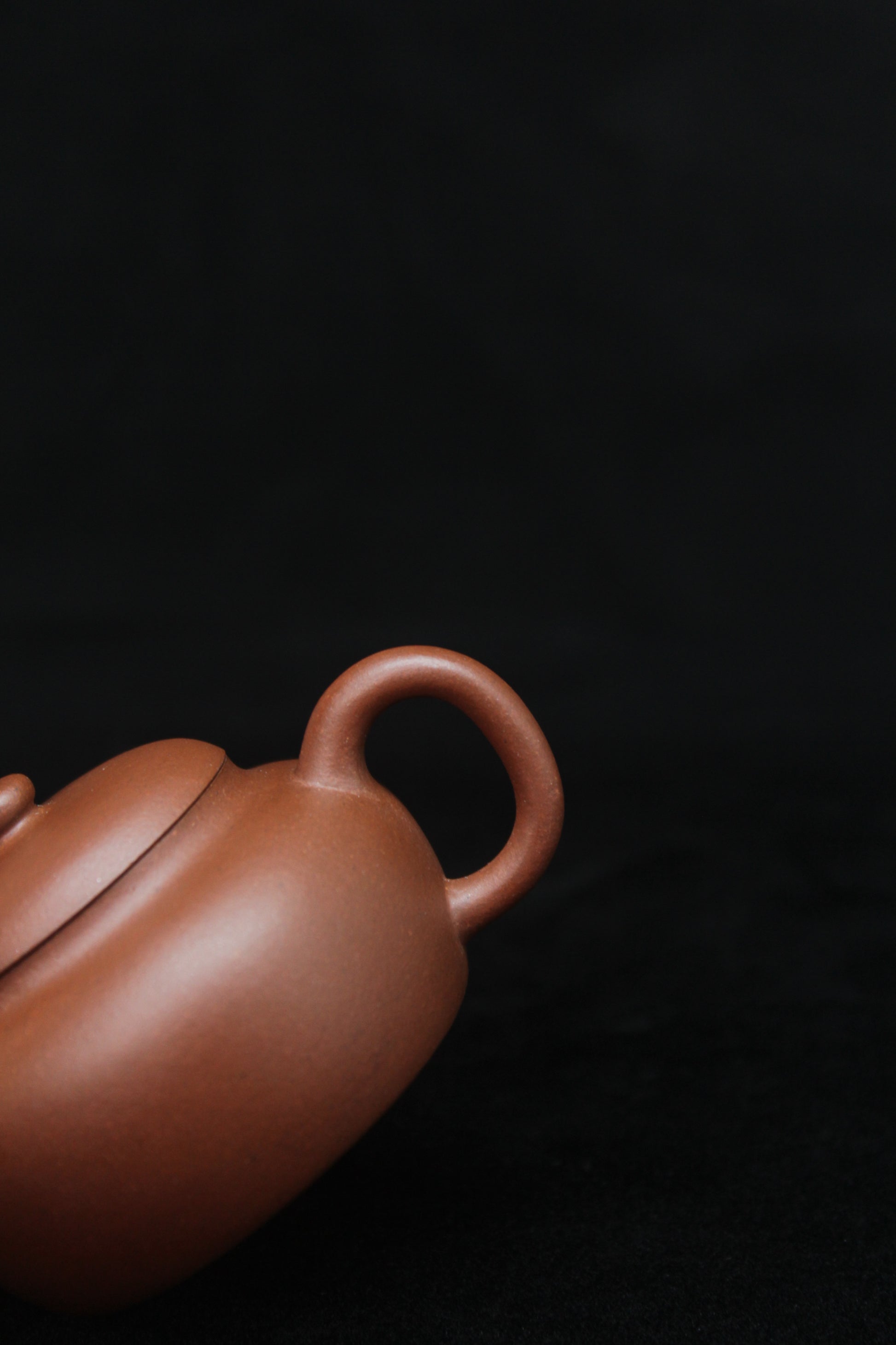 Handle of a vintage small Yixing teapot made of dicaoqing purple clay