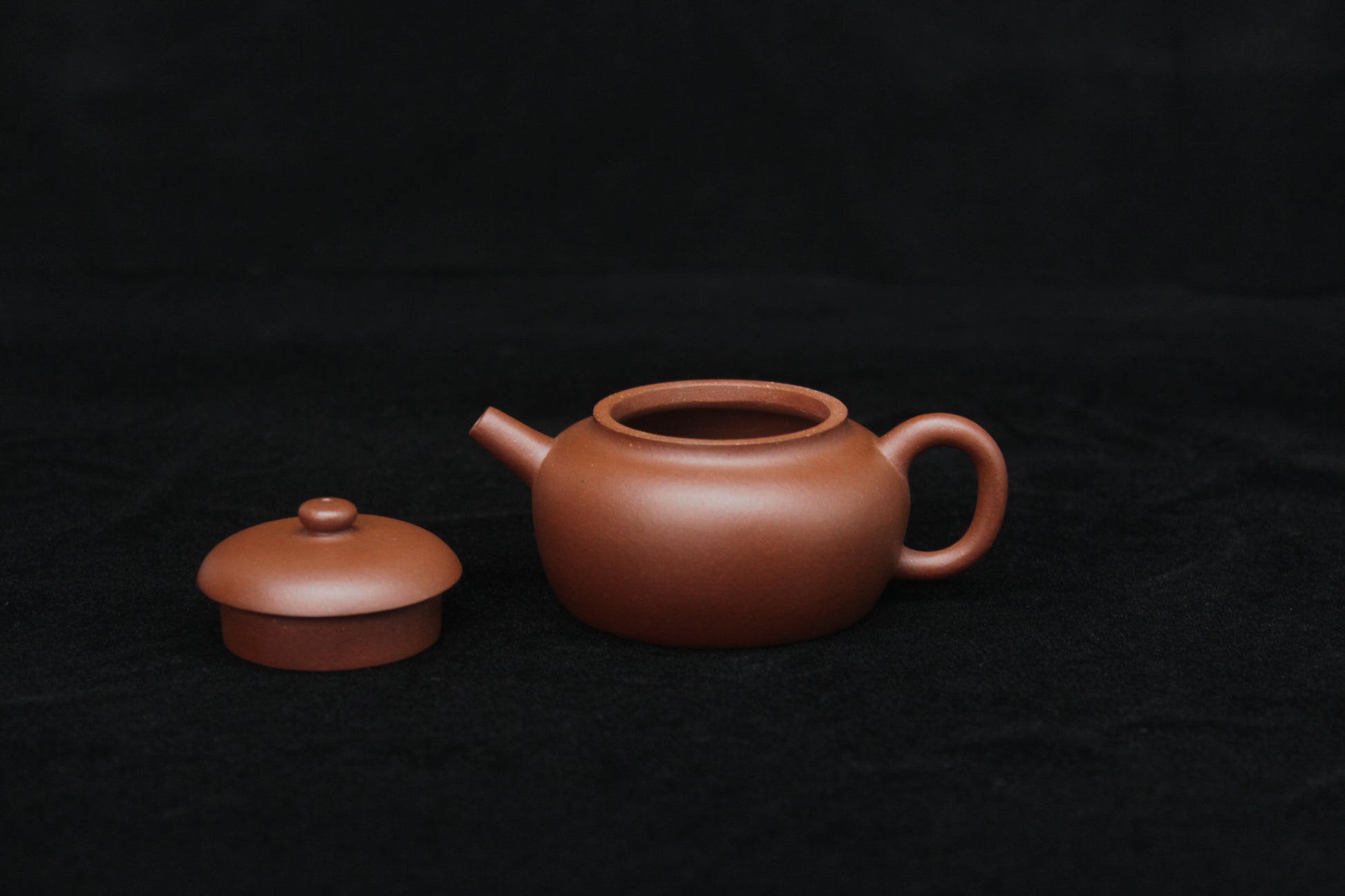 Detail of a vintage small Yixing teapot made of dicaoqing purple clay