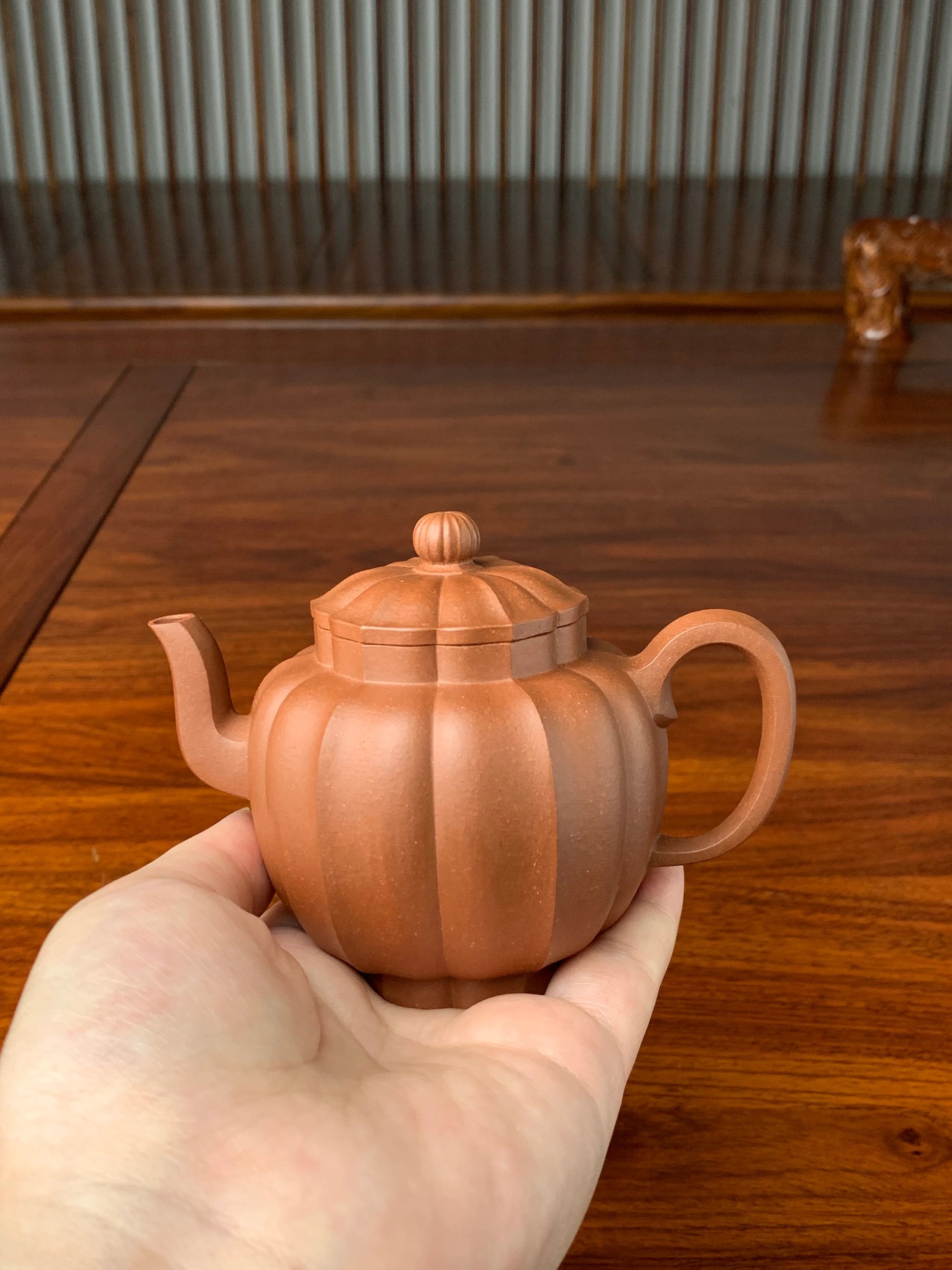 Carefully inspect the teapot while holding it in hand.
