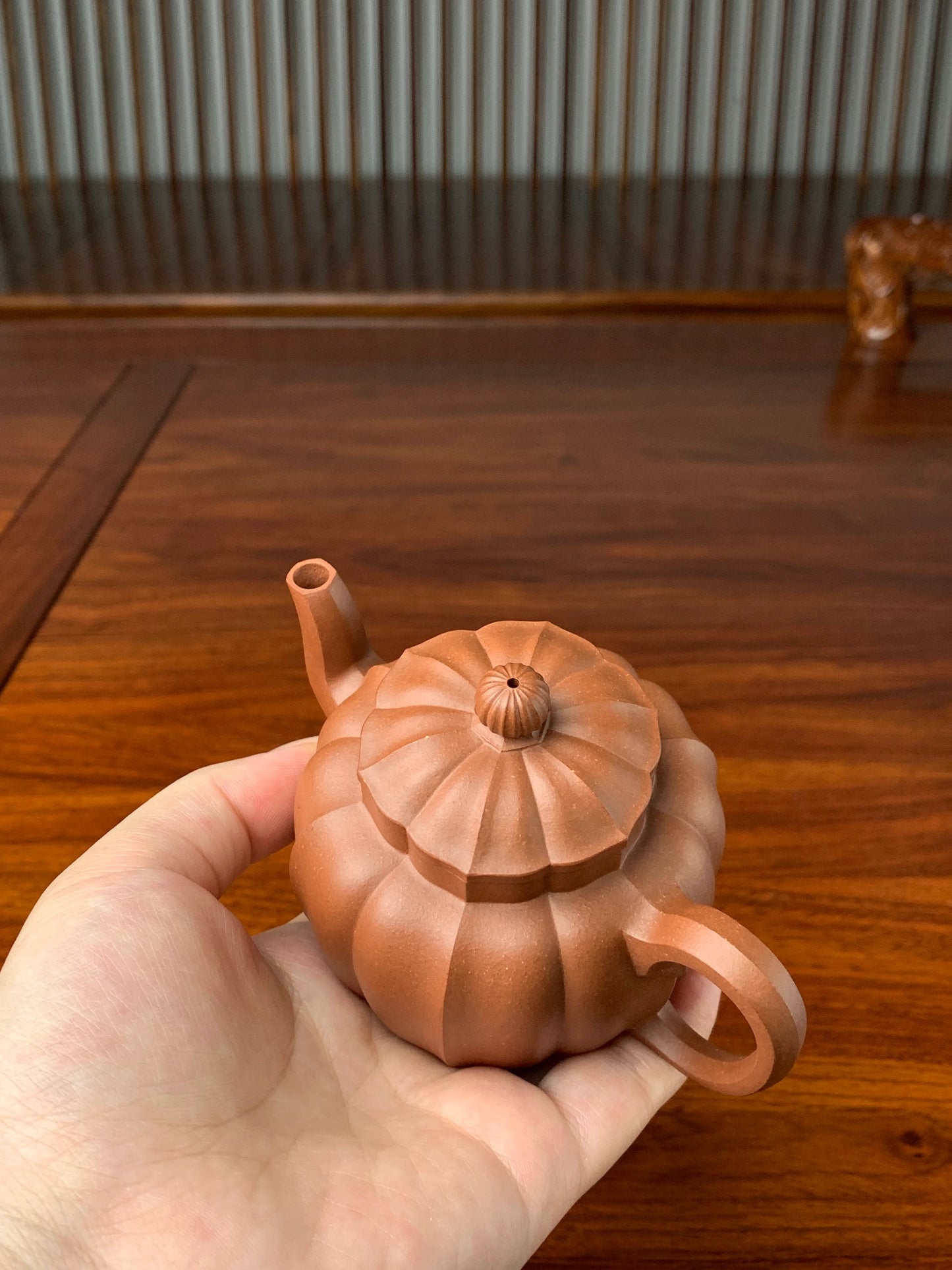 Hold the teapot in our hand and carefully inspect the details.
