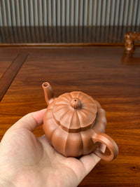 Hold the teapot in our hand and carefully inspect the details.