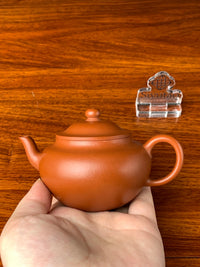 We hold the teapot in hand and find it has a beautiful form