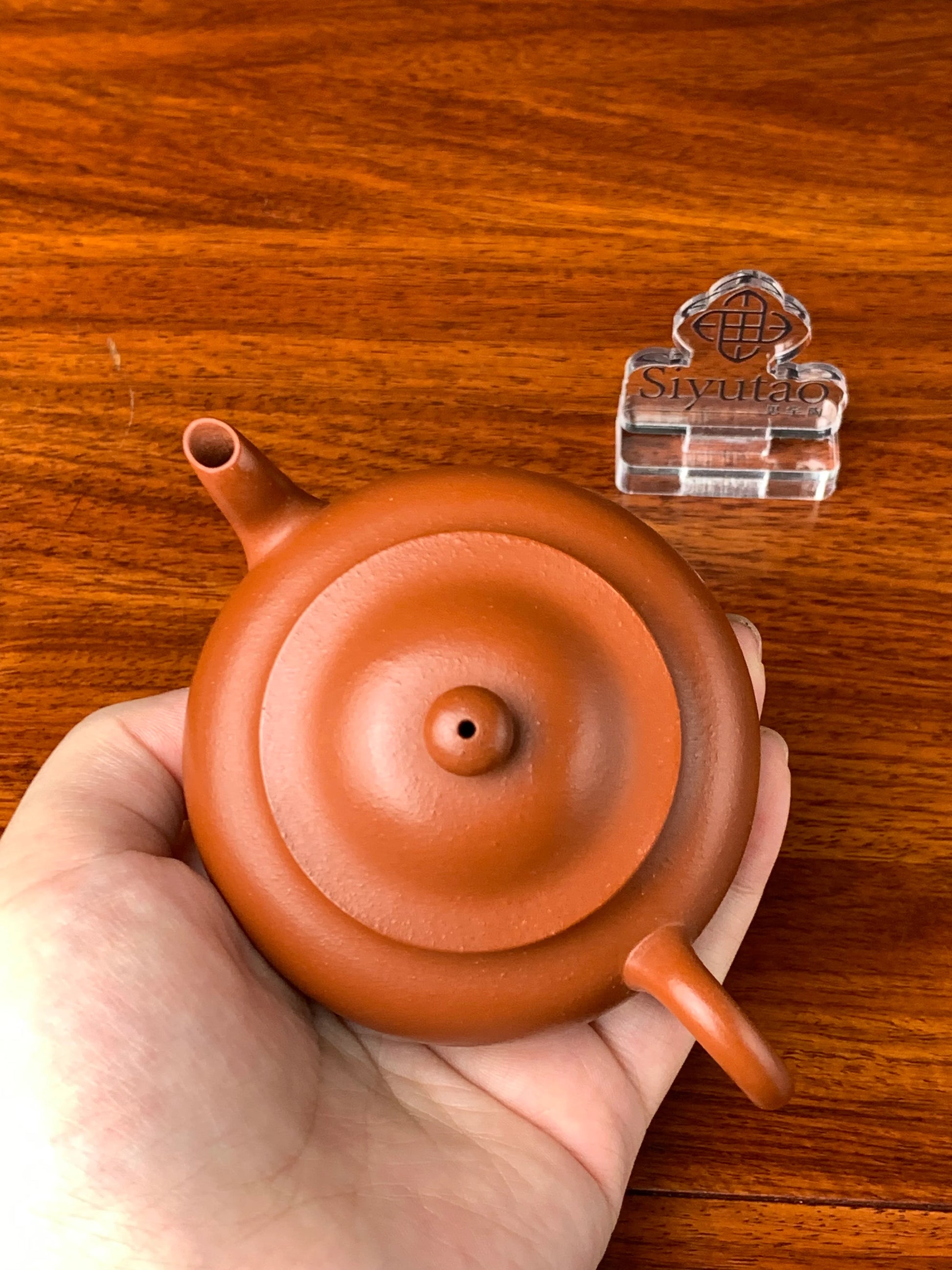We hold the teapot in our hands and personally inspect its quality.