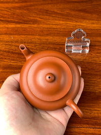 We hold the teapot in our hands and personally inspect its quality.