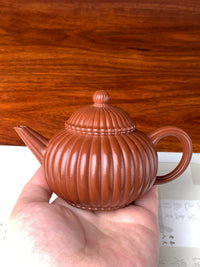 We hold the teapot in our hands to inspect its form and aesthetic beauty