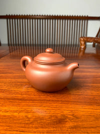handmade yixing teapot named fang gu on the table left view