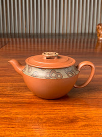 the front view of the yxing zisha clay teapot named bring wealth on the table