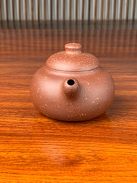 the front view of the yixing zisha clay teapot on the table