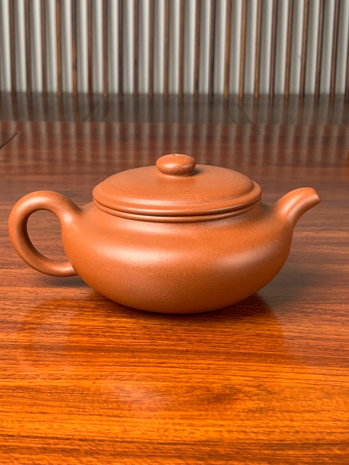 the back view of the yixing zisha clay teapot named bian fu