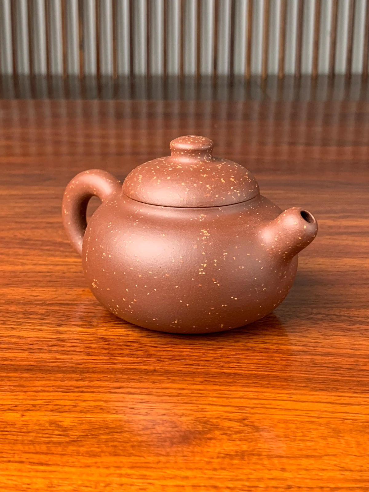 the left view of the yixing zisha clay teapot on the table