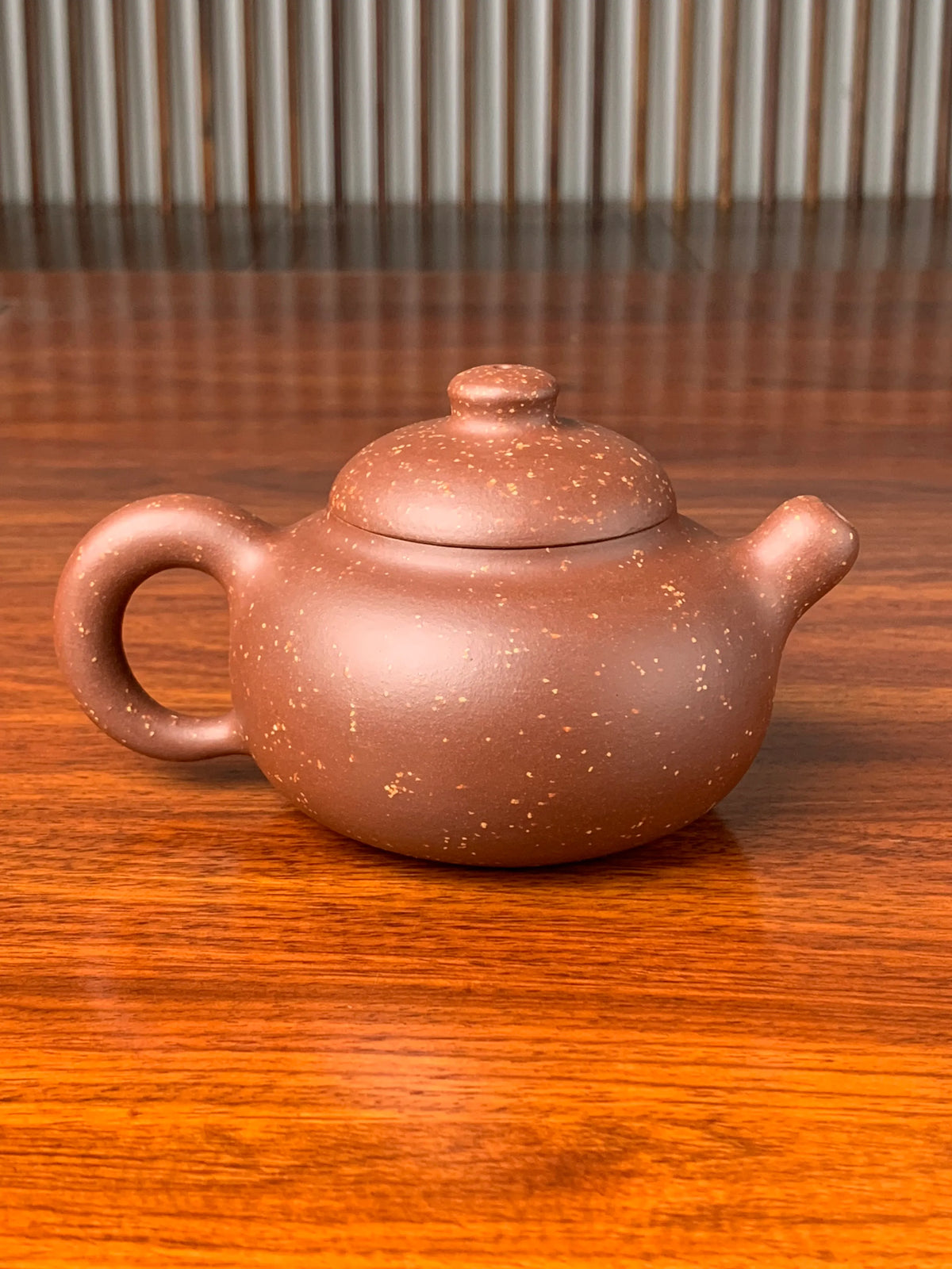 the back view of the yixing zisha clay teapot on the table