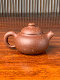 the back view of the yixing zisha clay teapot on the table