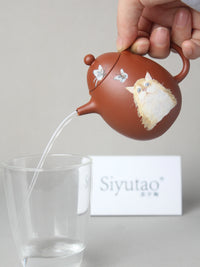 perfect pour of dragon egg zisha teapot with cat painting
