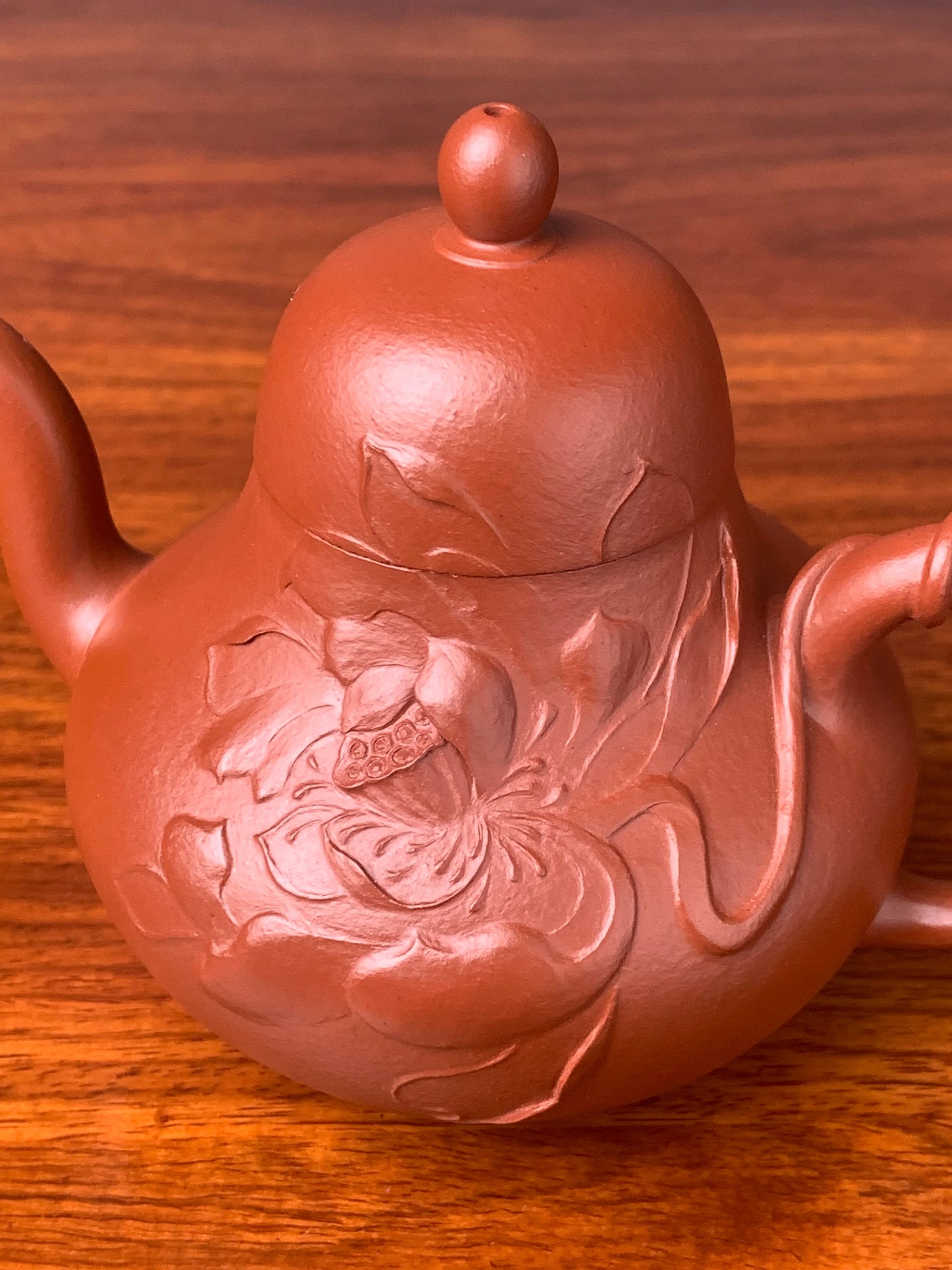 Close-up side view of the lotus sculpture on the teapot body
