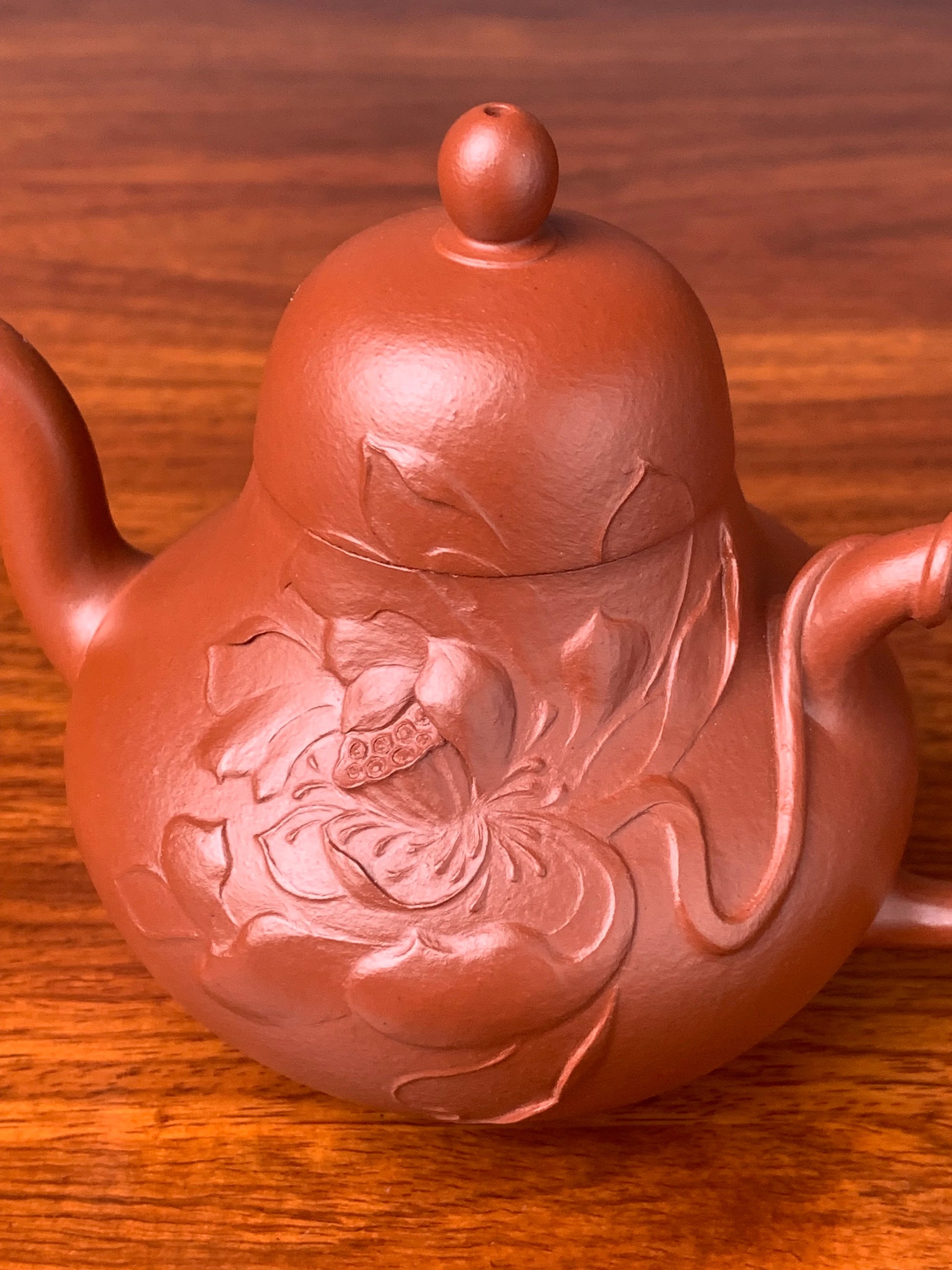 Close-up side view of the lotus sculpture on the teapot body