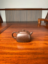the back view of the zisha teapot on the table