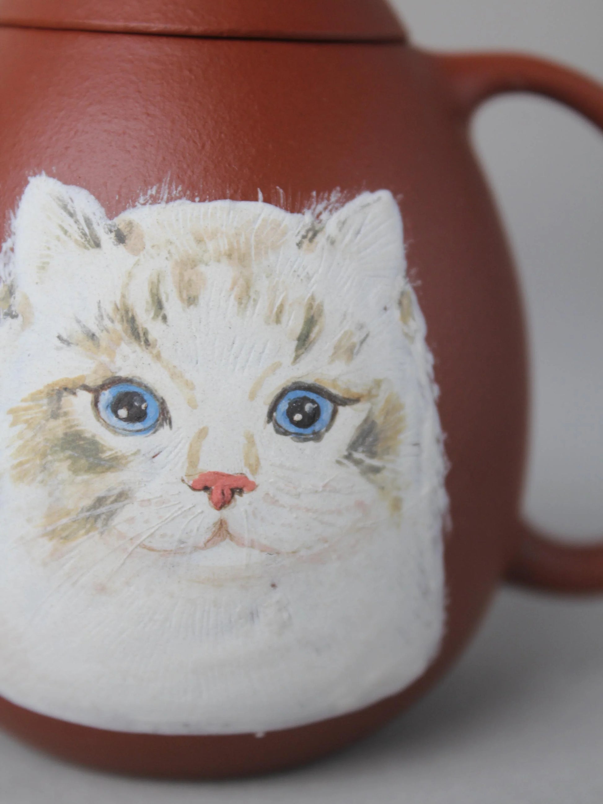 the detail of the cat painting on the zisha teapot